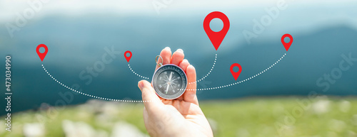 Traveler holding compass in hand for searching direction outdoor. Person use compass to find location photo