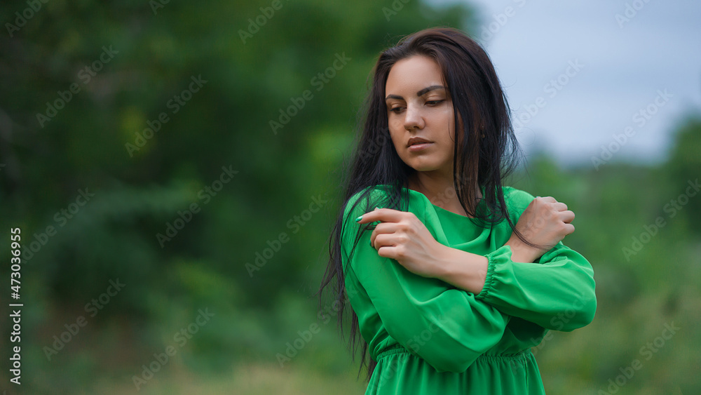 A girl walks in the park in a long green dress. Emotionally smiles. Green dress with chiffon and long sleeves. A girl walks in the park in a long green dress. Emotionally smiles. Green dress with chiffon and long sleeves.