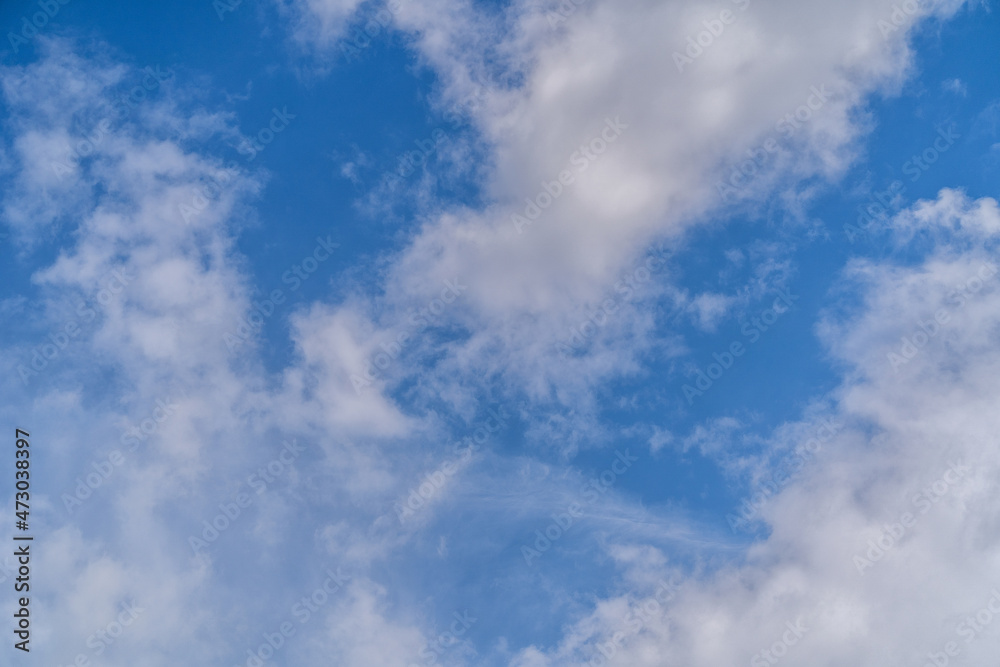 Cloudscape with pink sunset clouds in a blue sky.