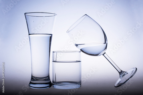 Glasses filled with water, water pours into a glass with splashes