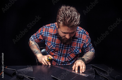 Worker of leather producing leather workpiece photo