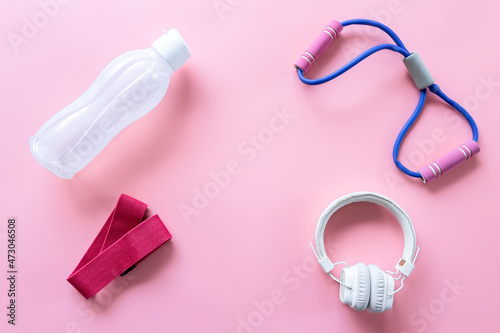 Sports equipment items on pink background, flat lay.