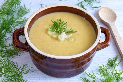 Cauliflower cream soup in a brown stoneware dish