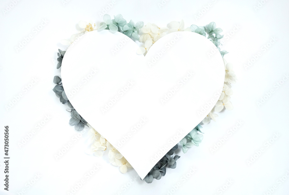 Flowers composition from blue and yellow flowers in the form of a heart on white background. Spring, summer template for your projects