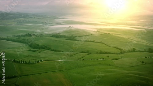 Flying over the foggy Tuscany Italy landscape at dawn