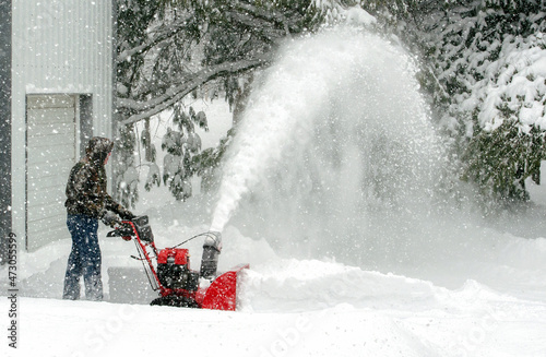 Blowing snow and clearing a path during winter photo