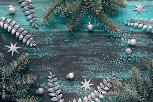 Silver Christmas panoramic background with fir and eucalyptus twigs, glass balls, exotic fern leaves. Acrylic background in brown and turquoise. Flat lay, top view Xmas background with stars.