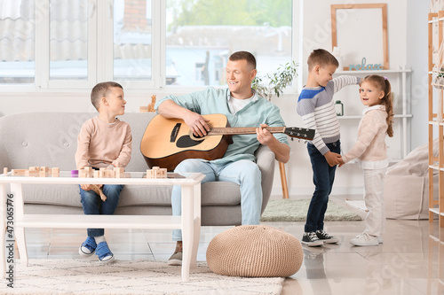 Father playing guitar and l...