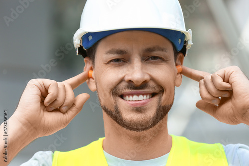 Male worker putting ear plu...