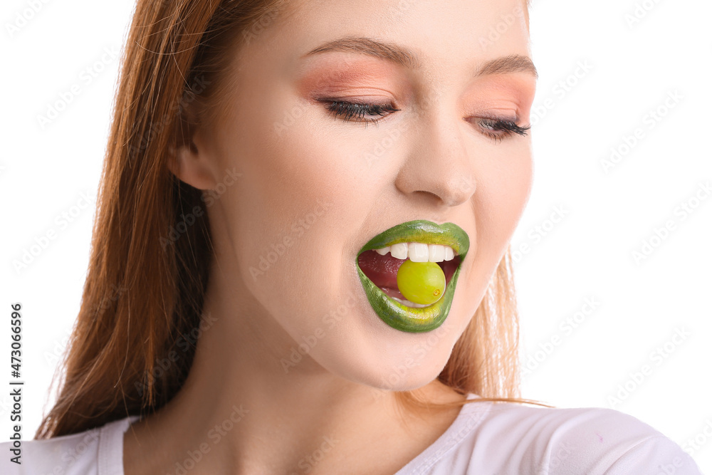 Beautiful young woman with unusual makeup and grape on white background Beautiful young woman with unusual makeup and grape on white background