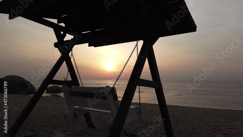 A lonely rocking chair on the beach where the morning sun rises