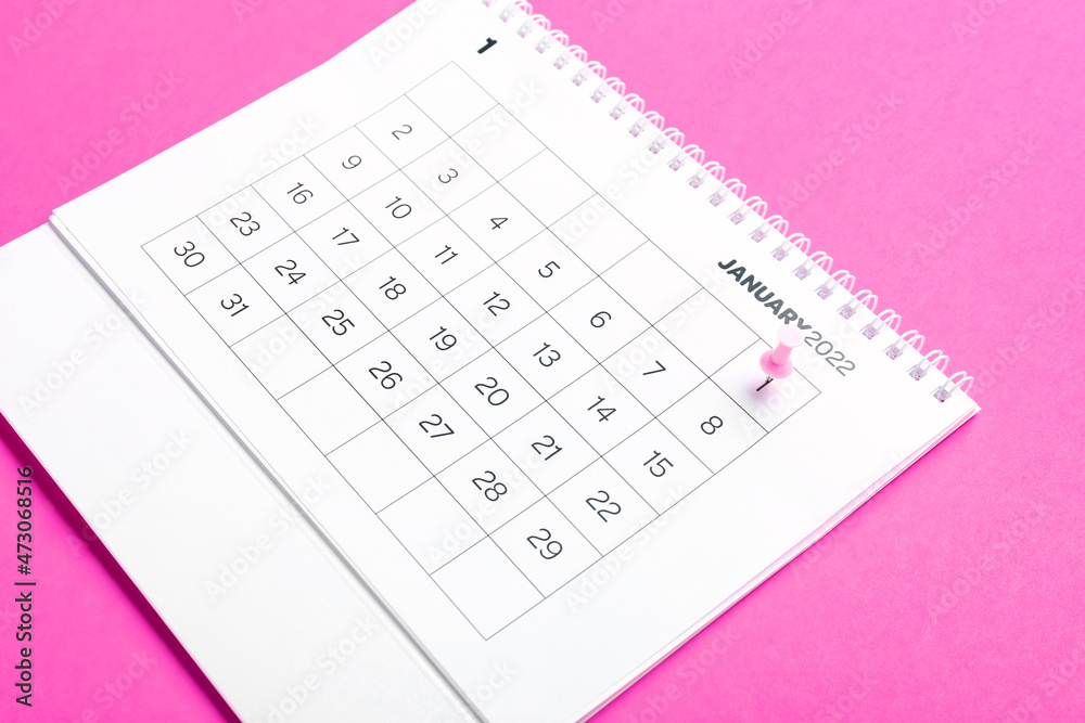 Flip paper calendar for January 2022 and pin on color background Flip paper calendar for January 2022 and pin on color background