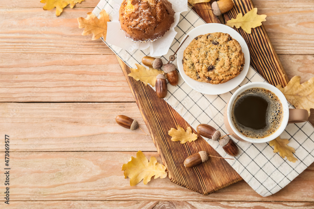 Autumn composition with cup of coffee, tasty cupcake and cookie on wooden background Autumn composition with cup of coffee, tasty cupcake and cookie on wooden background