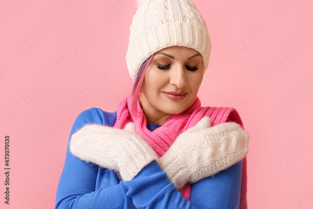 Woman in winter clothes on color background