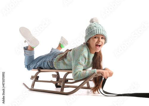 Sledding little girl on whi...