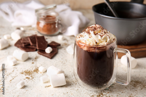 Glass cup of tasty hot chocolate on light background