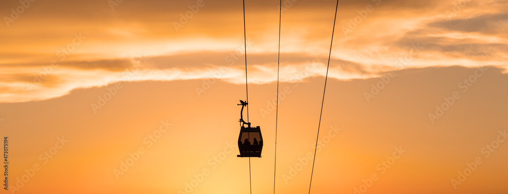 Silhouettes of people in the cabin of the aerial gondola road on a summer evening Silhouettes of people in the cabin of the aerial gondola road on a summer evening