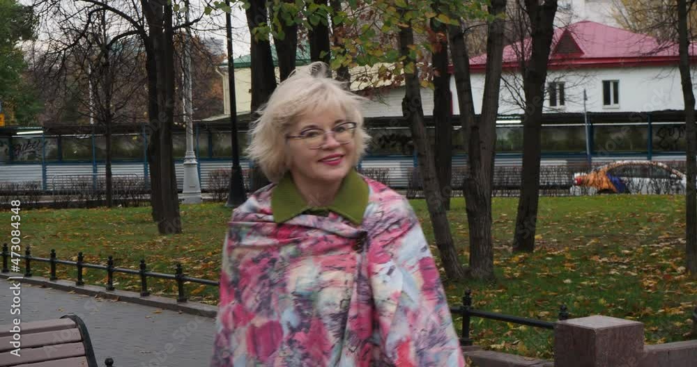 Autumn, seasons. A portrait of a happy smiling woman walks along the alleys of an autumn park in the center of Moscow. Hand held. Autumn, seasons. A portrait of a happy smiling woman walks along the alleys of an autumn park in the center of Moscow. Hand held.