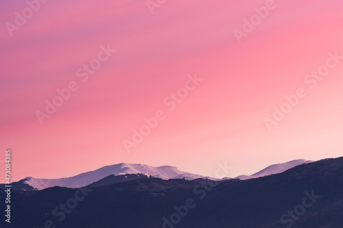 Stunning view of a snowcapped mountain range during a beautiful sunrise.