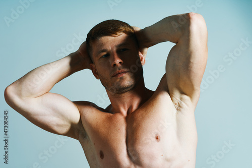 bodybuilder with muscular body posing press blue background