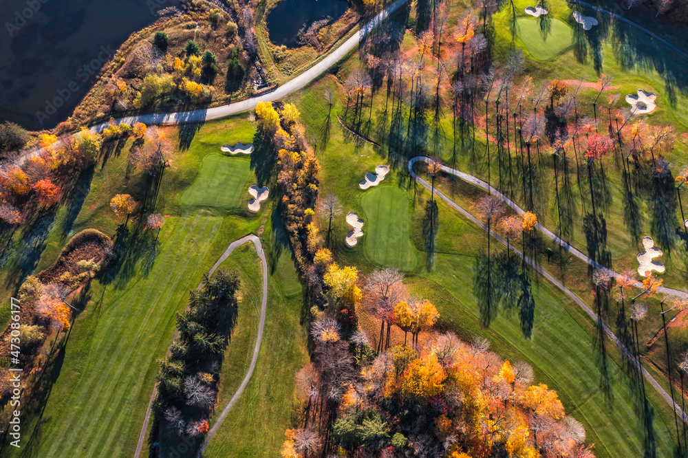 Aerial overhead view of golf course with morning light, fall season