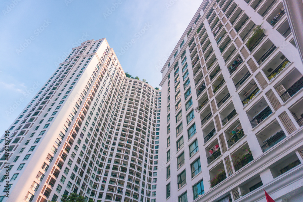 High-rise apartment buildings in the city center. Low angle shot of modern architecture in the blue sky. Futuristic cityscape view	