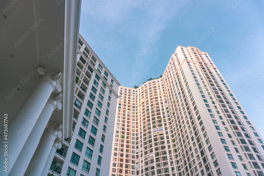 High-rise apartment buildings in the city center. Low angle shot of modern architecture in the blue sky. Futuristic cityscape view	