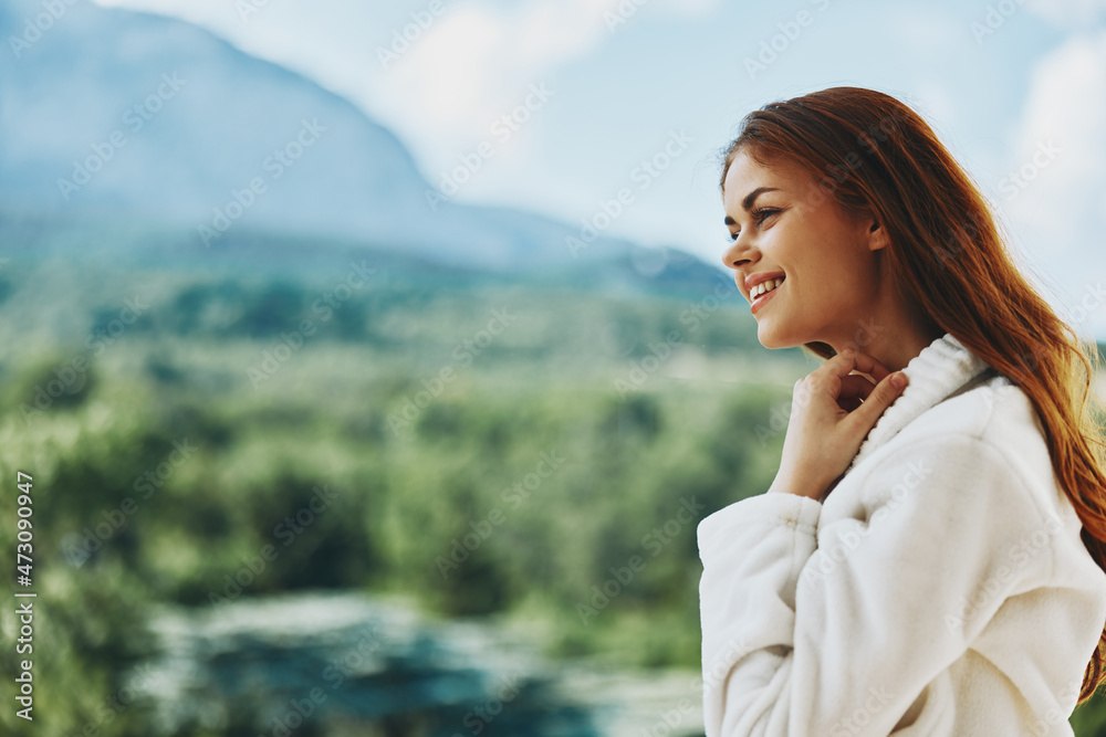 Portrait of young woman long hair in a white bathrobe staying on the balcony in a hotel Portrait of young woman long hair in a white bathrobe staying on the balcony in a hotel