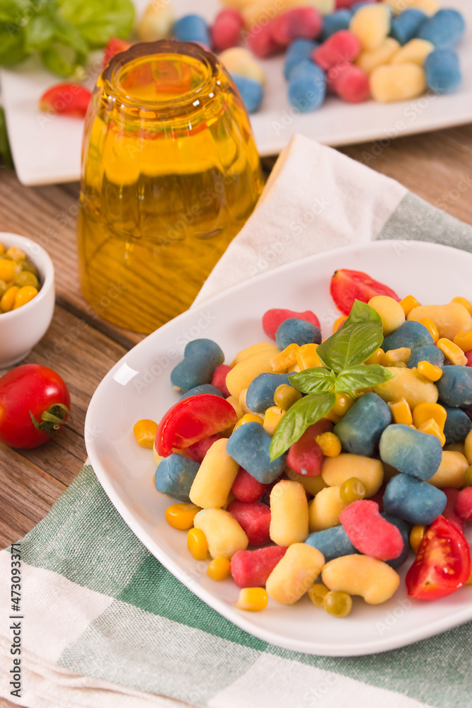 Colored gnocchi with vegetables and sweet corn.