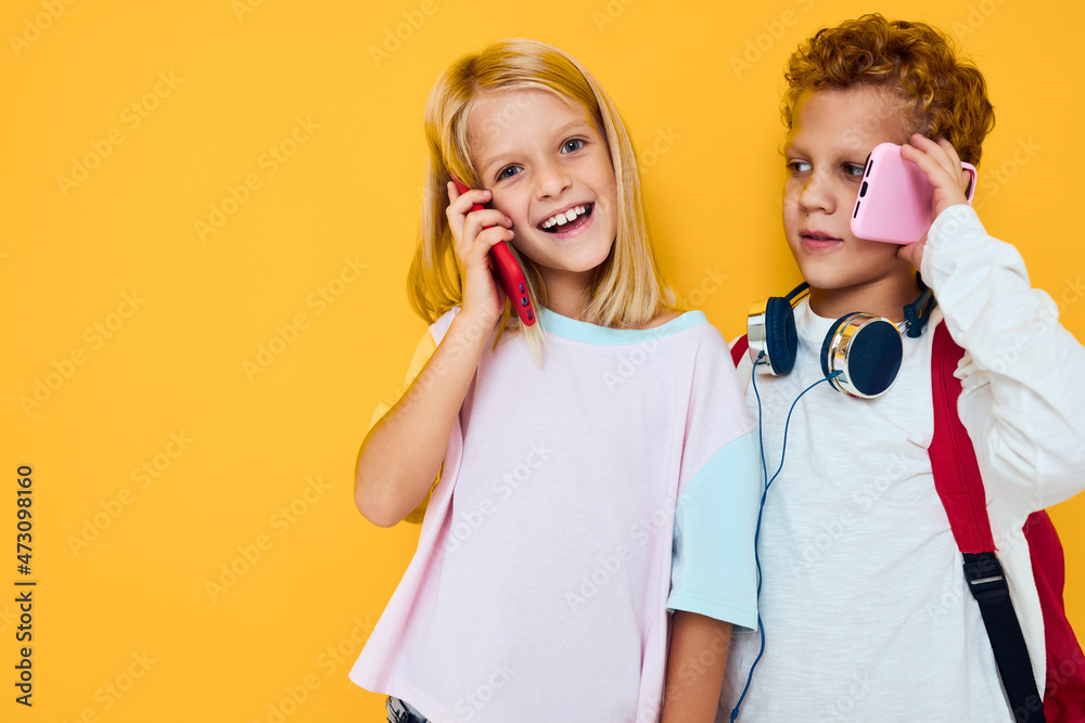 Photo of two small kids girl looking at the phone entertainment communication Studio education concept Photo of two small kids girl looking at the phone entertainment communication Studio education concept