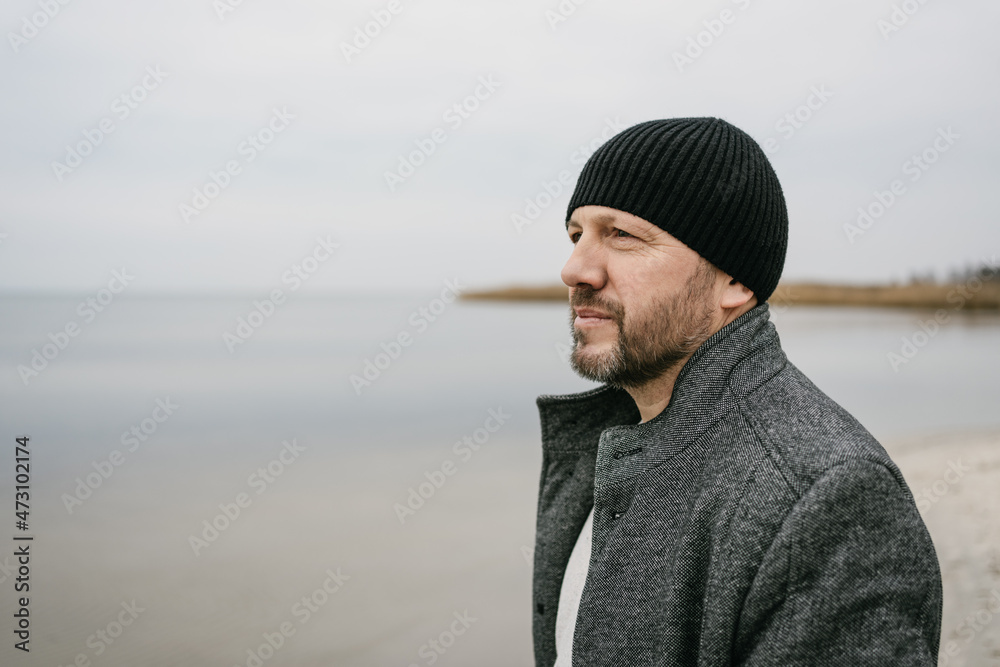 Contemplative middle-aged man staring out over a flat sea