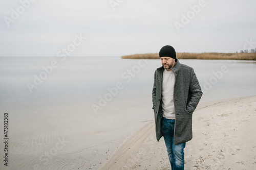 Troubled depressed man walking along a deserted beach