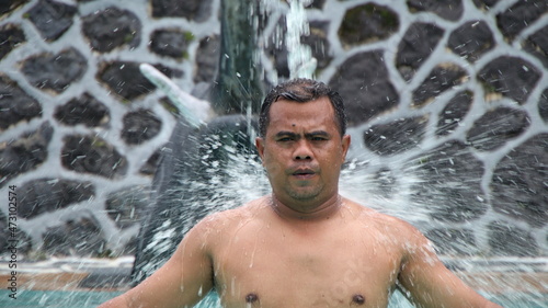 Man taking a shower with outdoor shower. ritual by bathing in holy water. Man relaxing in massage pool. frolicking in the shower.