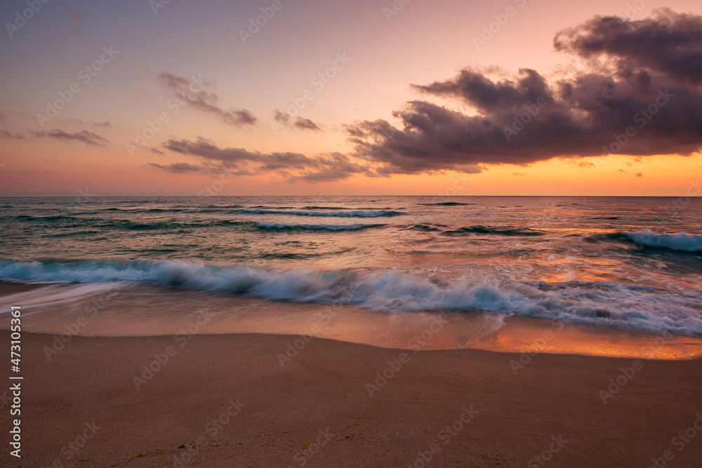 calm sea scenery at dawn. waves wash empty sandy beach at twilight. relax and summer vacation concept. warm velvet season weather with clouds on the sky