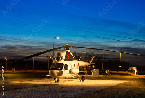 Small helicopter at the airport, against the background of a beautiful sky © ArturSniezhyn