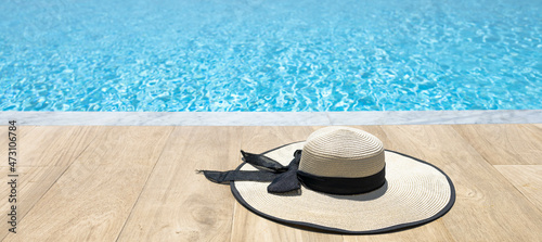 A straw hat is placed on the edge of the pool..