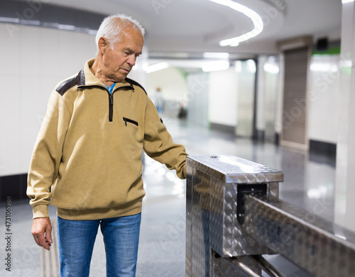 Elderly passenger pays for a metro ride using mobile phone