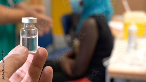 Europe, Italy, December 2021 - Vaccination against covid-19 Coronavirus epidemic with Pfizer vaccine hospital - black woman child Omicron variant vaccine - African patient, vaccine on pediatric age 