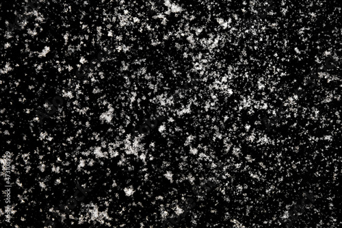 white icy snowflakes isolated on black background, natural background