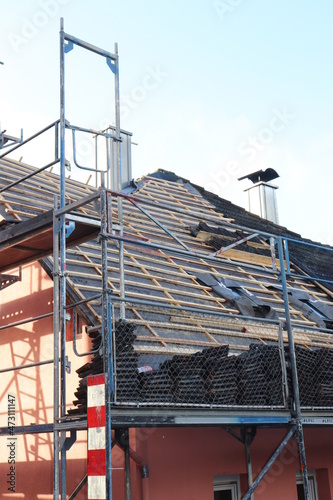 Gerüst an einem Haus mit abgedeckten Dach Sanierung Dachsanierung Dach decken Dachdecker Haussanierung eingerüstet Handwerk Dachziegel