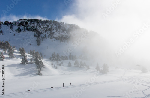 paysage alpin: Chamrousse et le massif de Belledonne sous la neige en hiver avec des nuages dans la vallée © jef 77