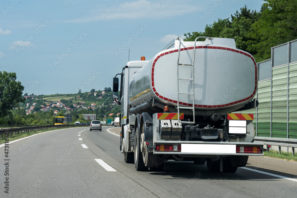 Cistern tank truck on a highway under the blue clear sky
