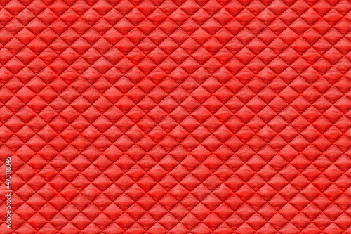 Seamless texture of red quilted fabric, cloth sewn into the cell, stitching. Texture of the blanket, red textile