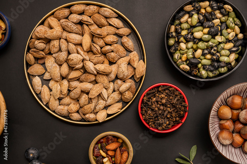 dried beas edamame, shelled almonds, dried fruits and oats on black background photo