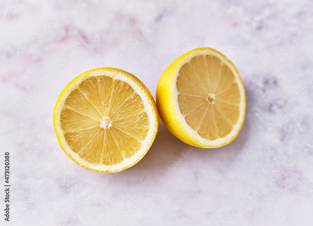 Two lemon halves fruit on a marble surface Two lemon halves fruit on a marble surface