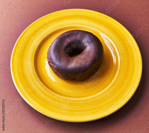  Plate of chocolate doughnut on a brown background
