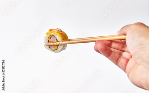  Chopsticks holding single shrimp uramaki sushi isolated on white background
