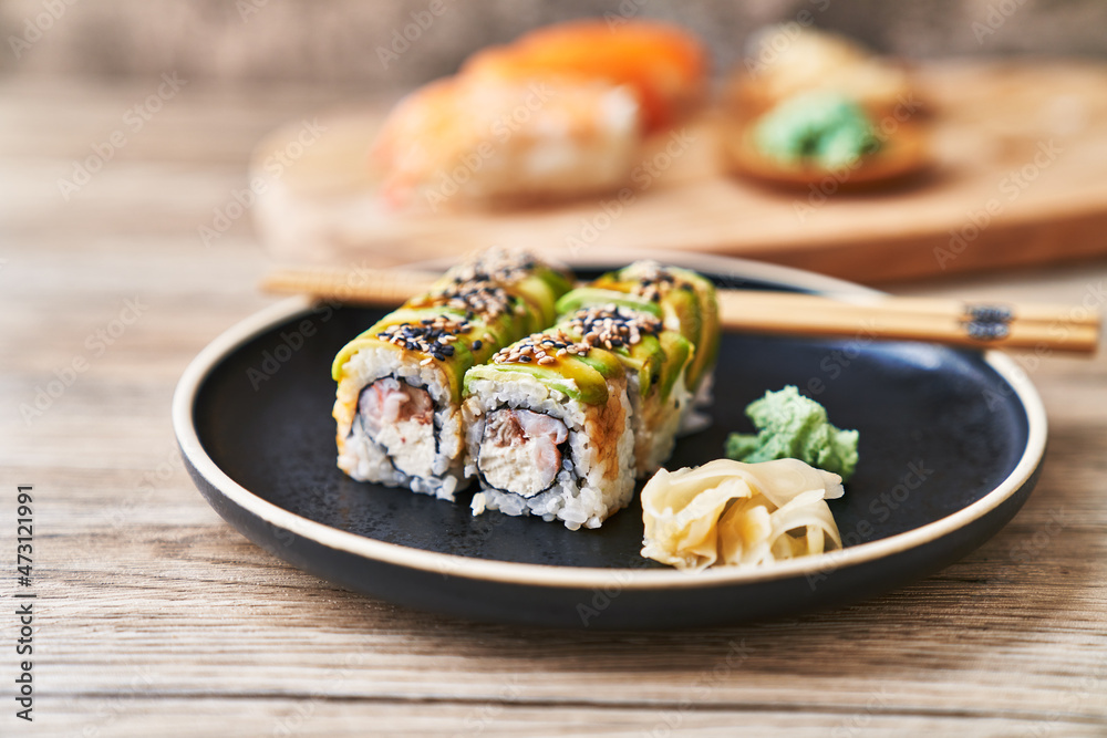 Plate of shrimp and cheese cream uramaki sushi on a wooden surface Plate of shrimp and cheese cream uramaki sushi on a wooden surface