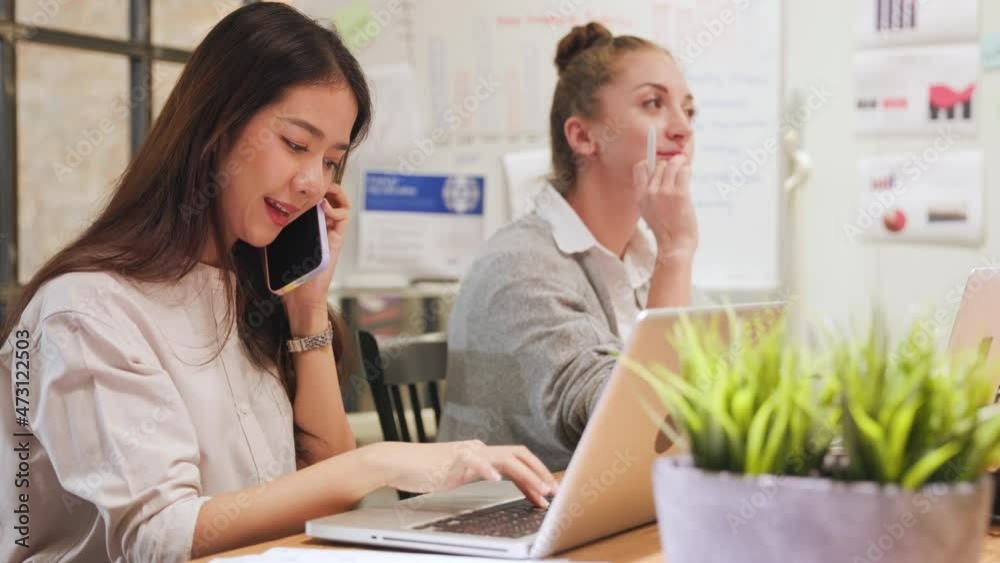 Asian young business woman professional talking on phone using laptop sit at home office desk, happy female customer make mobile call confirming online Asian young business woman professional talking on phone using laptop sit at home office desk, happy female customer make mobile call confirming online