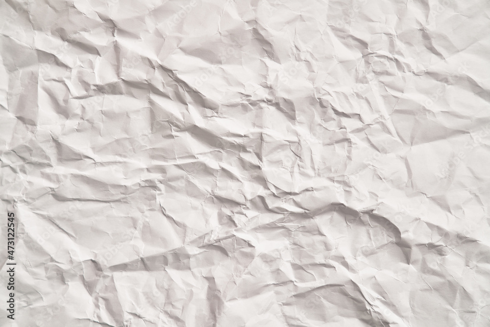 Fototapeta premium White crumpled paper texture with wrinkles. Damaged and torn sheet